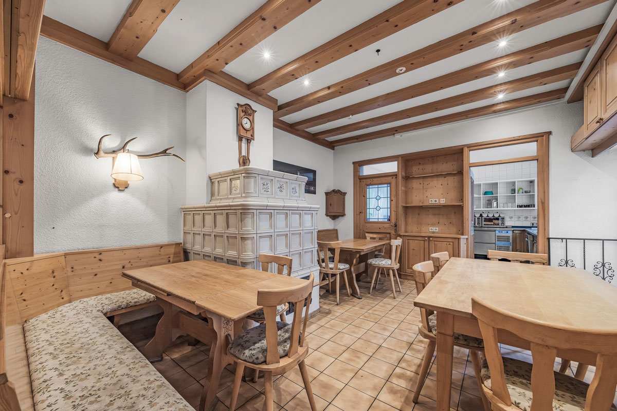 Gemütliches Zimmer mit Holzdecken und -möbeln sowie Kachelöfen und Wanddekoration.